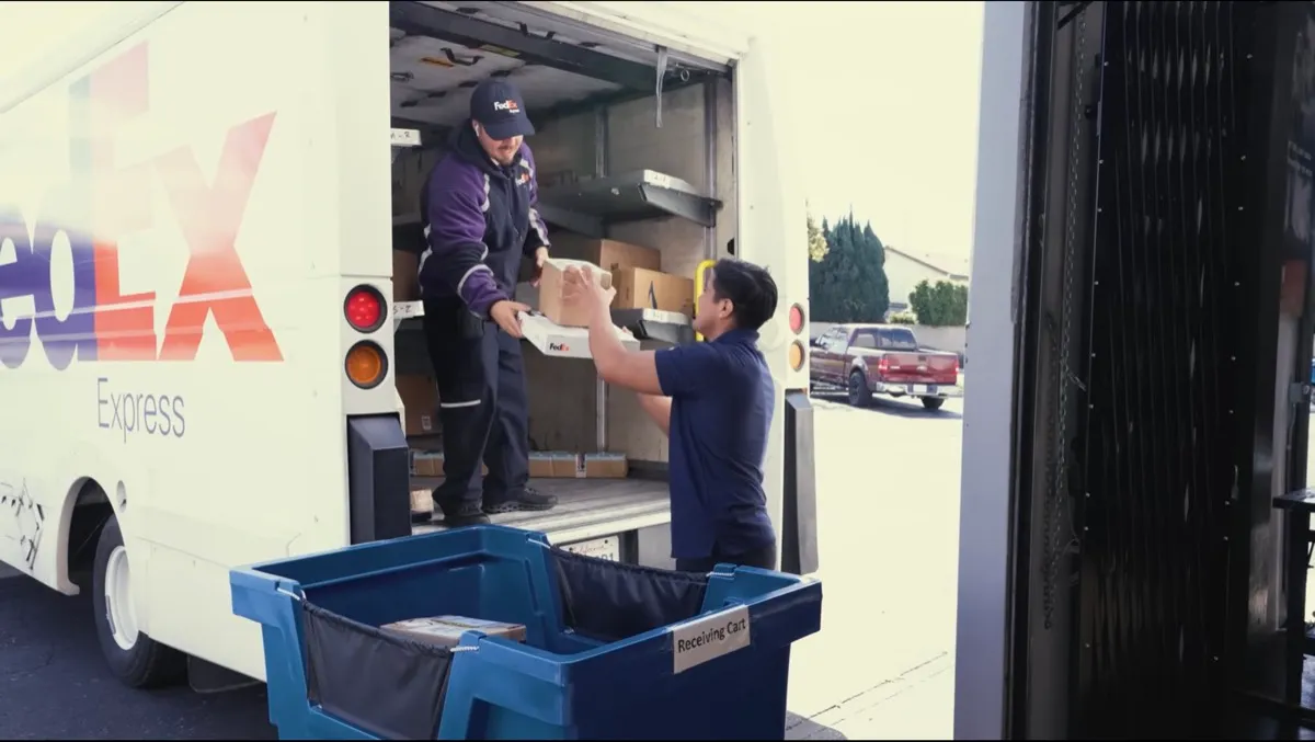 ASAP staff loading a package into a FedEx Express truck
